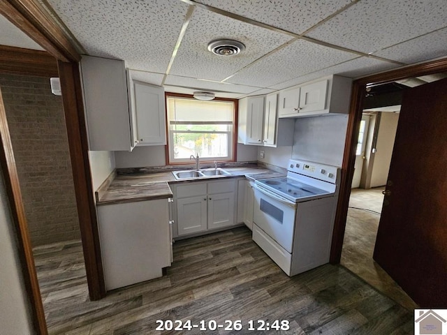 kitchen with dark wood-type flooring, white electric range, sink, a paneled ceiling, and white cabinets