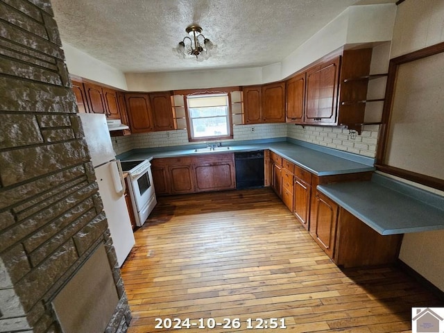 kitchen featuring sink, white appliances, an inviting chandelier, backsplash, and light wood-type flooring