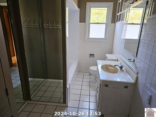 full bathroom with tile walls, separate shower and tub, vanity, tile patterned floors, and toilet