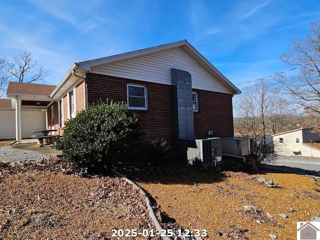 view of side of property featuring central AC unit and a patio