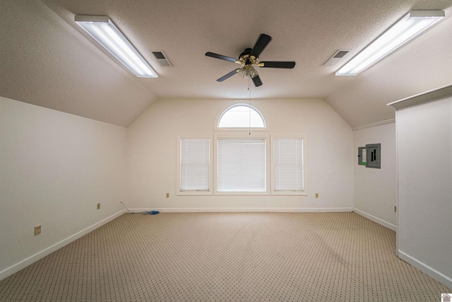 bonus room with light carpet, a textured ceiling, vaulted ceiling, and ceiling fan