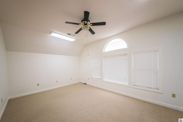 additional living space featuring lofted ceiling, carpet flooring, a textured ceiling, and ceiling fan