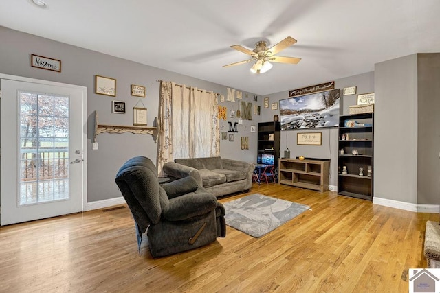 living room featuring ceiling fan and light hardwood / wood-style flooring