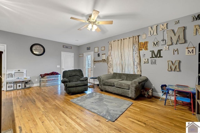 living room with wood-type flooring and ceiling fan