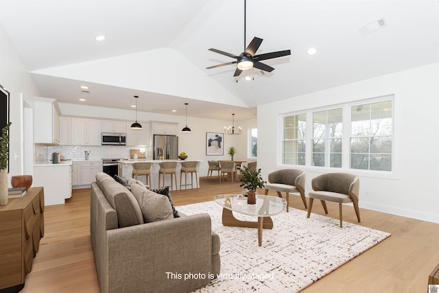 living room featuring ceiling fan with notable chandelier, high vaulted ceiling, and light wood-type flooring