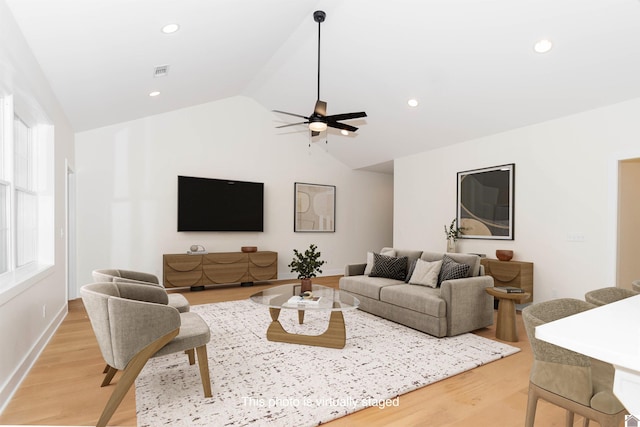 living room featuring ceiling fan, lofted ceiling, and light hardwood / wood-style floors