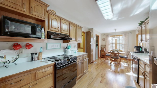 kitchen with decorative light fixtures, light hardwood / wood-style flooring, and black appliances