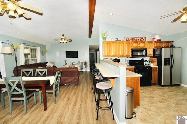 kitchen with a breakfast bar, ceiling fan, stainless steel refrigerator with ice dispenser, lofted ceiling with beams, and black range with gas stovetop