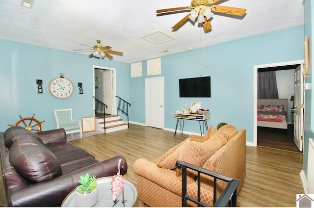 living room featuring hardwood / wood-style floors, a textured ceiling, and ceiling fan