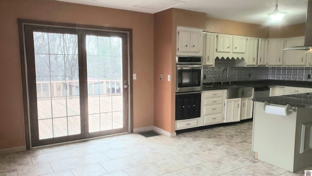 kitchen with sink, tasteful backsplash, exhaust hood, oven, and stainless steel oven