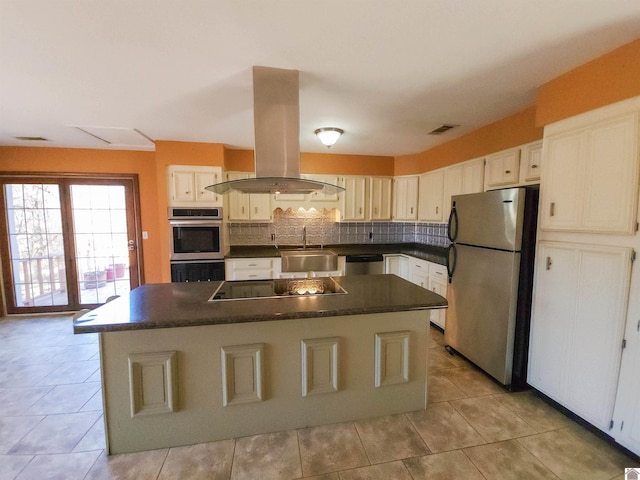 kitchen with light tile patterned floors, appliances with stainless steel finishes, a kitchen island, island exhaust hood, and decorative backsplash