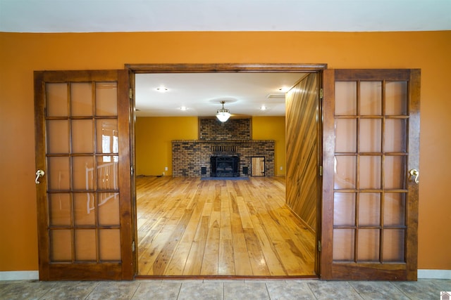 unfurnished living room featuring a brick fireplace and hardwood / wood-style flooring