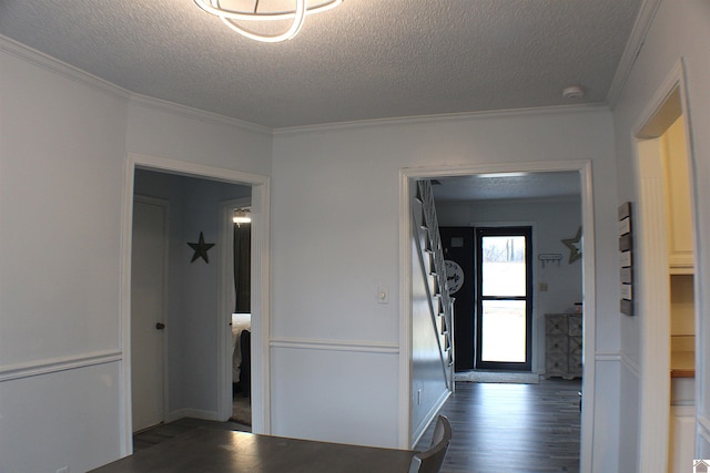 hallway with ornamental molding, a textured ceiling, and dark hardwood / wood-style flooring