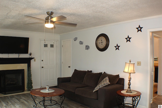 living room featuring crown molding, ceiling fan, and wood-type flooring