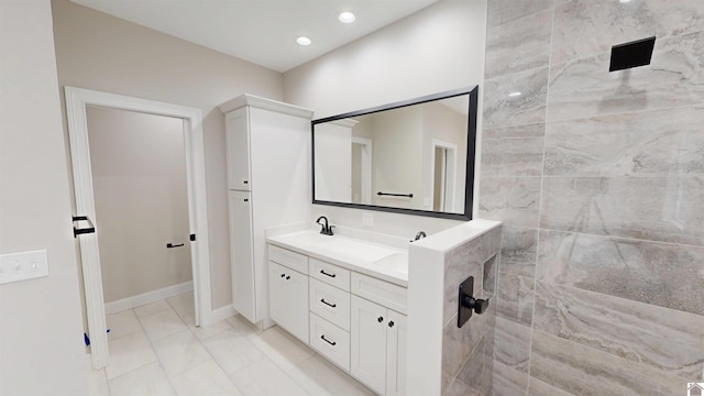 bathroom featuring tiled shower and vanity