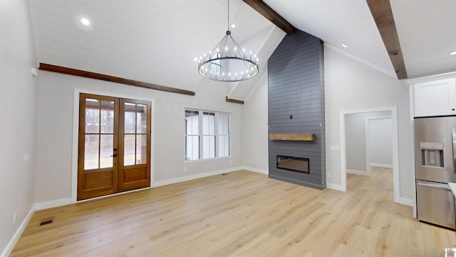 unfurnished living room with french doors, high vaulted ceiling, light wood-type flooring, a large fireplace, and beamed ceiling