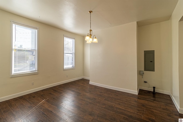 spare room with a notable chandelier, electric panel, and dark hardwood / wood-style floors