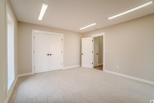 unfurnished bedroom with a closet and light carpet