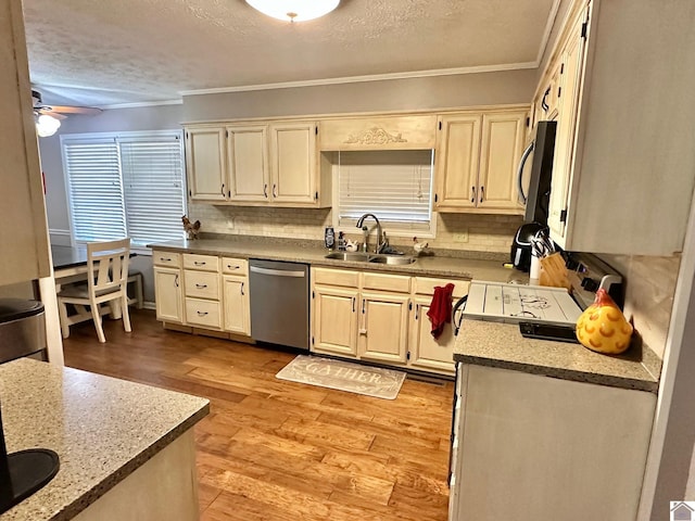 kitchen featuring sink, crown molding, appliances with stainless steel finishes, light hardwood / wood-style floors, and a textured ceiling