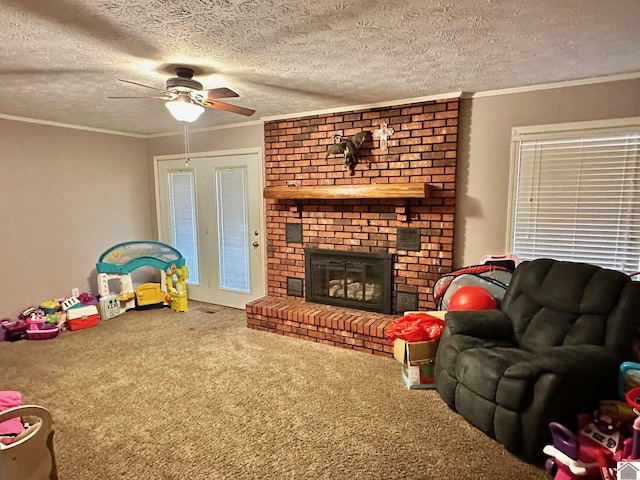 carpeted living room featuring crown molding, a fireplace, a textured ceiling, and ceiling fan