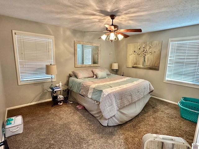 bedroom with ceiling fan, carpet flooring, and a textured ceiling