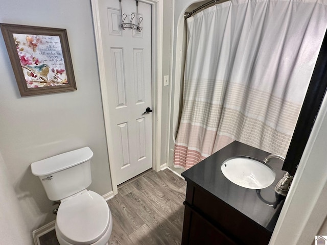 bathroom with vanity, hardwood / wood-style floors, walk in shower, and toilet