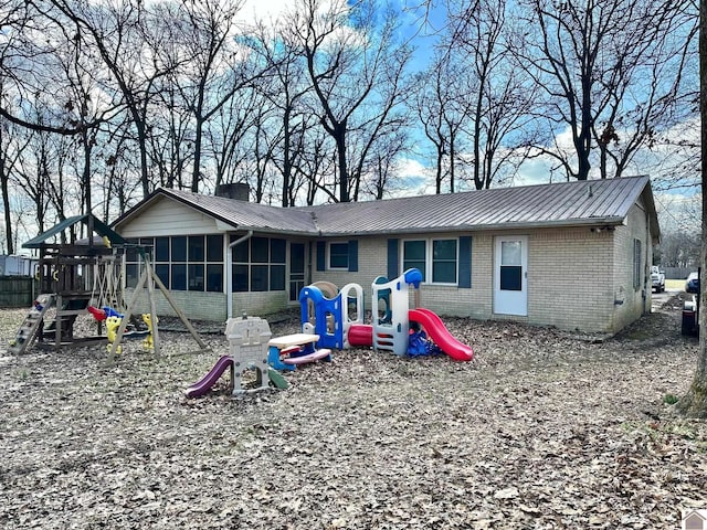 back of property featuring a sunroom and a playground