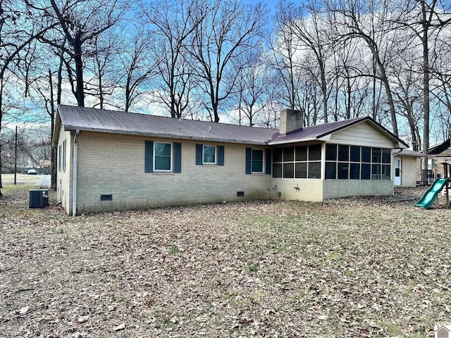 rear view of property with central AC unit and a sunroom