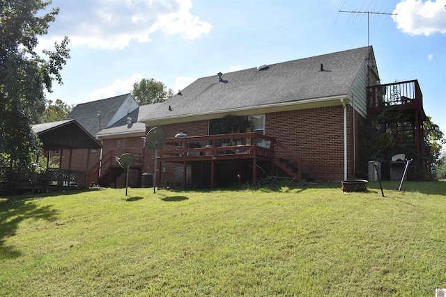 rear view of property featuring a wooden deck, a yard, and an outdoor fire pit