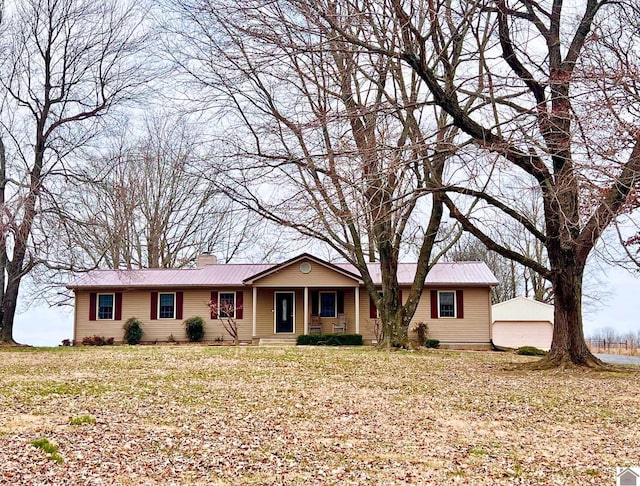 single story home with an outbuilding, a garage, and a front yard