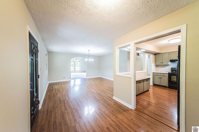 interior space with hardwood / wood-style flooring, a notable chandelier, and a textured ceiling