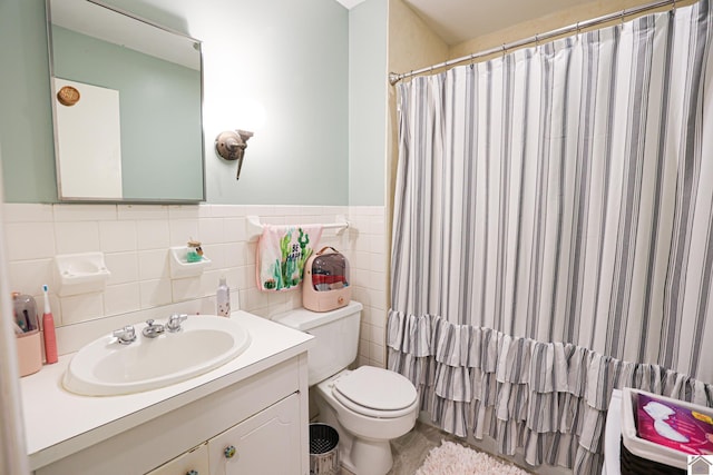 bathroom featuring vanity, curtained shower, toilet, and tile walls