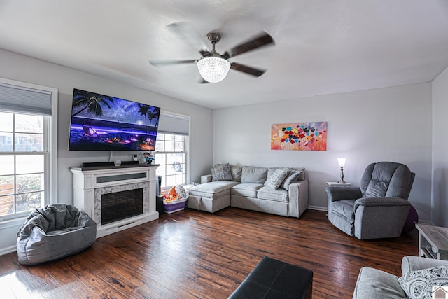 living room with ceiling fan, a premium fireplace, and dark hardwood / wood-style flooring