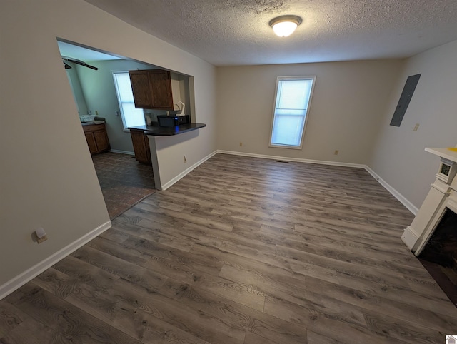 unfurnished living room featuring plenty of natural light, dark hardwood / wood-style floors, and a textured ceiling