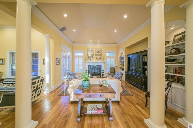 living room featuring built in features, high vaulted ceiling, decorative columns, ornamental molding, and light hardwood / wood-style flooring