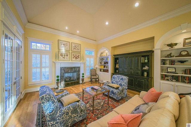 living room featuring a premium fireplace, wood-type flooring, and a healthy amount of sunlight