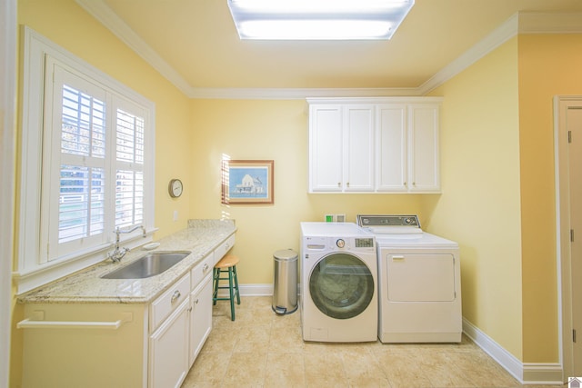 laundry room with light tile patterned flooring, washing machine and clothes dryer, sink, crown molding, and cabinets