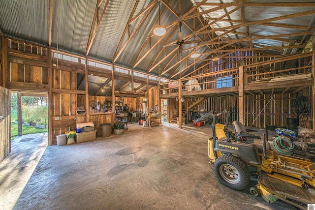 miscellaneous room with concrete flooring and high vaulted ceiling