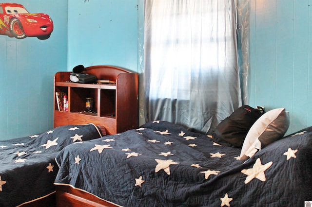 bedroom featuring wood walls