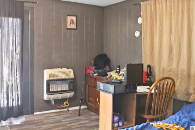 home office with hardwood / wood-style floors, heating unit, and wooden walls