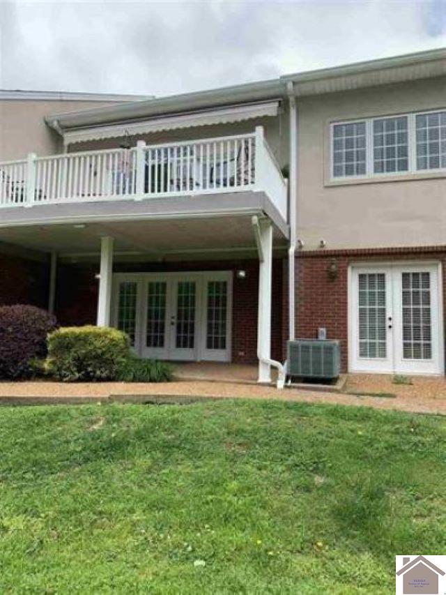 rear view of property with central AC unit, a lawn, french doors, and a balcony