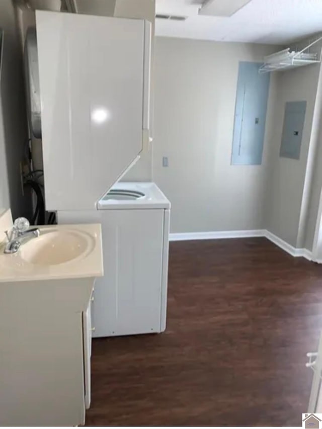 interior space featuring sink, electric panel, and dark hardwood / wood-style flooring