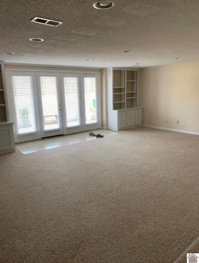 carpeted spare room with a textured ceiling