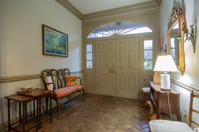 foyer with ornamental molding and a healthy amount of sunlight