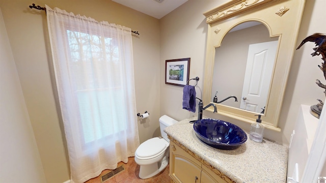 bathroom featuring toilet, vanity, and tile patterned flooring