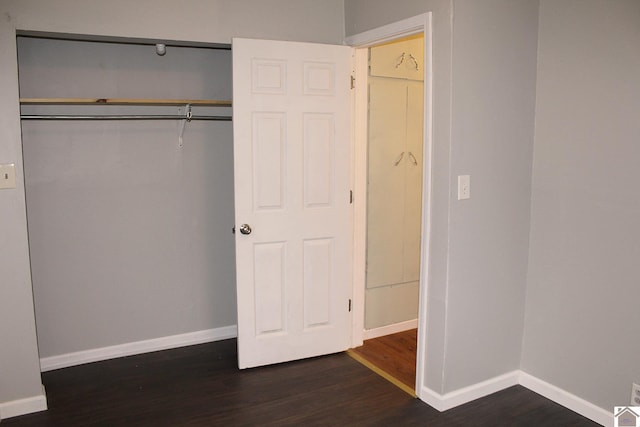 unfurnished bedroom featuring a closet and dark hardwood / wood-style floors