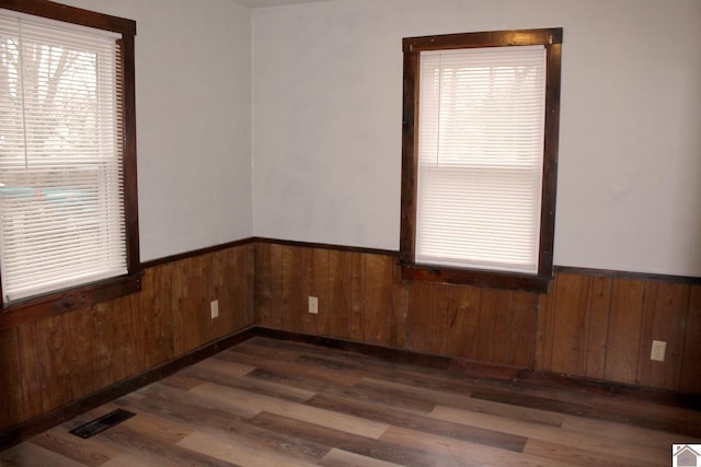 spare room with wooden walls and dark hardwood / wood-style floors