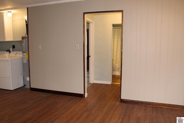 washroom with water heater, separate washer and dryer, and dark hardwood / wood-style floors