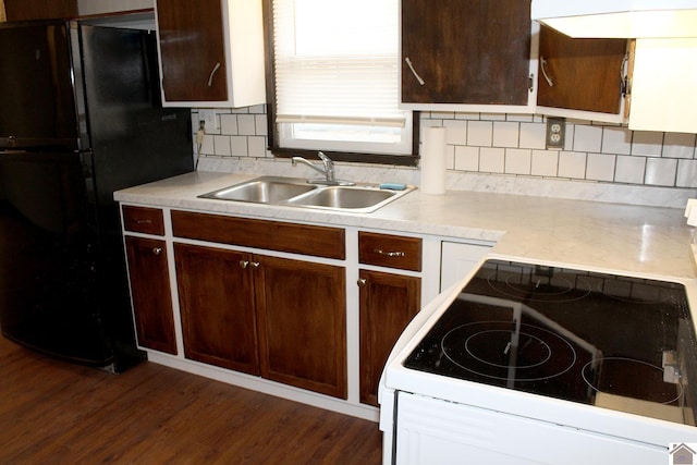 kitchen with sink, dark hardwood / wood-style flooring, decorative backsplash, white range with electric cooktop, and black fridge