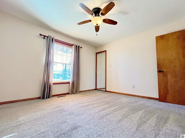 carpeted empty room featuring ceiling fan